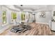 Open dining room featuring modern lighting, wood-look floors, and bright windows to screened porch at 3215 Oxleas Ct, Cumming, GA 30041