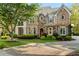 Beautiful stone and brick home with a brick paver driveway and lush landscaping at 3215 Oxleas Ct, Cumming, GA 30041