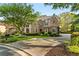 A sprawling brick home sits behind a circular driveway with manicured landscaping at 3215 Oxleas Ct, Cumming, GA 30041