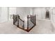 Bright hallway with carpeted floors, wrought iron railing, and views of the stairs at 3215 Oxleas Ct, Cumming, GA 30041
