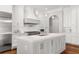 Kitchen with stainless appliances, custom hood, pot filler and large island with white countertop and custom cabinets at 3215 Oxleas Ct, Cumming, GA 30041