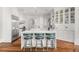 This large white kitchen features custom cabinets, stainless appliances, and a large island with chairs for entertaining at 3215 Oxleas Ct, Cumming, GA 30041