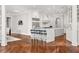 Gourmet kitchen with stainless steel appliances and a large island, open to the living room and dining area at 3215 Oxleas Ct, Cumming, GA 30041