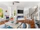 Bright open-concept living room with fireplace, staircase, hardwood floors, and comfortable seating at 3215 Oxleas Ct, Cumming, GA 30041