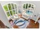 Living room view from above features soaring windows, a swimming pool, hardwood floors, and comfortable sofas at 3215 Oxleas Ct, Cumming, GA 30041