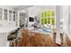 Open living space with white bar, modern fireplace, high windows, and hardwood floors at 3215 Oxleas Ct, Cumming, GA 30041