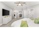 A brightly lit main bedroom, shows TV, ceiling fan, white furniture and doorway to the hallway at 3215 Oxleas Ct, Cumming, GA 30041