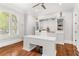 Well-lit home office with custom built-ins, hardwood floors, and plantation shutters at 3215 Oxleas Ct, Cumming, GA 30041