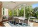 Spacious screened porch featuring outdoor dining and serene wooded views at 3215 Oxleas Ct, Cumming, GA 30041