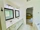 Bright bathroom with a dual sink vanity, black framed mirrors and a view of the adjacent bedroom at 365 Friars Head Dr, Suwanee, GA 30024