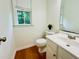 Half bathroom featuring a white vanity and toilet with a window for natural light at 365 Friars Head Dr, Suwanee, GA 30024