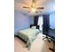 A tidy bedroom with blue walls, a ceiling fan, a bed and a desk with computer at 365 Friars Head Dr, Suwanee, GA 30024