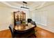 Elegant dining room featuring hardwood floors, large windows, and a stylish china cabinet at 365 Friars Head Dr, Suwanee, GA 30024
