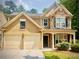 Inviting two-story home featuring a stone facade, a two-car garage, and well-manicured landscaping at 365 Friars Head Dr, Suwanee, GA 30024