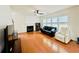 Bright living room features a ceiling fan, fireplace, and large windows for ample natural light at 365 Friars Head Dr, Suwanee, GA 30024