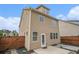 View of the tan siding of the home's exterior with a fenced-in backyard and a small concrete patio at 4044 Elsdon Dr, Austell, GA 30106