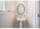Powder room featuring pedestal sink, oval mirror, and decorative fixtures at 4044 Elsdon Dr, Austell, GA 30106