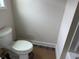 Compact half bathroom features a standard toilet with a white porcelain finish and dark vinyl flooring at 3536 Dogwood Pass, Stonecrest, GA 30038