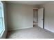Bright bedroom featuring a large window and neutral carpeting with convenient access to hallway at 3536 Dogwood Pass, Stonecrest, GA 30038
