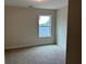 Bright bedroom featuring a large window and neutral carpeting at 3536 Dogwood Pass, Stonecrest, GA 30038