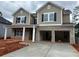 Two-story home with brick and siding, complemented by a two-car garage and inviting front porch at 3536 Dogwood Pass, Stonecrest, GA 30038
