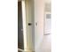 A hallway with white walls and trim, showcasing both an open doorway and a door with a glass pane at 3536 Dogwood Pass, Stonecrest, GA 30038