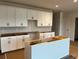 Bright kitchen with white cabinets, drawers, and island in new home construction at 3536 Dogwood Pass, Stonecrest, GA 30038