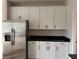 Stylish kitchen featuring white cabinets, stainless steel refrigerator and dark countertops at 3536 Dogwood Pass, Stonecrest, GA 30038