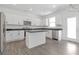 A bright, modern kitchen featuring white cabinets, stainless steel appliances, and a center island at 3536 Dogwood Pass, Stonecrest, GA 30038