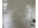 Clean white shower with built-in shelving for storage and a chrome shower head with faucet at 3536 Dogwood Pass, Stonecrest, GA 30038