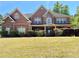 Beautiful brick home with stone accents, covered front porch, manicured hedges, and a well-kept lawn at 220 Fannin Ln, Mcdonough, GA 30252