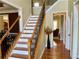 Elegant foyer with hardwood floors, staircase with iron railings, and natural light flowing in from windows at 220 Fannin Ln, Mcdonough, GA 30252