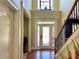 Bright foyer with hardwood floors, glass front door, staircase, and transom window at 220 Fannin Ln, Mcdonough, GA 30252