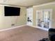 Cozy living room featuring plush carpet, a built-in bookcase, and double doors at 220 Fannin Ln, Mcdonough, GA 30252