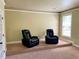 Carpeted living room featuring a step up and two leather reclining chairs at 220 Fannin Ln, Mcdonough, GA 30252