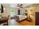 Comfortable bedroom features hardwood floors, a ceiling fan, and a large window bringing in ample light at 4820 Coppedge Trl, Peachtree Corners, GA 30096
