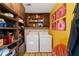 Convenient laundry room with storage cabinets, appliances and colorful artwork at 4820 Coppedge Trl, Peachtree Corners, GA 30096