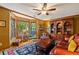 Inviting living room boasts a large bay window, ceiling fan and a cozy sitting area with a leather sofa at 4820 Coppedge Trl, Peachtree Corners, GA 30096