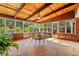 Bright sunroom with wood-paneled walls, tile floors, and multiple windows offering scenic views of the outdoors at 4820 Coppedge Trl, Peachtree Corners, GA 30096