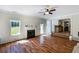 Bright living room featuring hardwood floors, a fireplace, and a ceiling fan at 6955 Pompas Ct, Douglasville, GA 30135