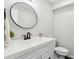 Modern bathroom features a sleek sink, round mirror, and stylish black hardware at 85 Lawson St, Buford, GA 30518
