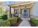 Cozy front porch with stone accents, covered entry and well manicured shrubs at 85 Lawson St, Buford, GA 30518