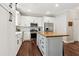 Well-lit kitchen with white cabinetry, stainless appliances, butcher block island, and hardwood flooring at 85 Lawson St, Buford, GA 30518