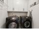 Modern laundry room with front-load Samsung washer and dryer and ample cabinet space at 85 Lawson St, Buford, GA 30518