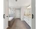 Well lit bathroom with tub, shower and double vanity with granite counters at 85 Lawson St, Buford, GA 30518