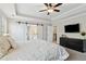 Bright main bedroom with tray ceiling, ceiling fan, and access to a stairway at 85 Lawson St, Buford, GA 30518