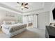 Bright main bedroom with tray ceiling, ceiling fan, and bathroom entrance with barn doors at 85 Lawson St, Buford, GA 30518