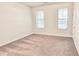Carpeted bedroom with two windows, neutral walls and a nearby doorway at 2102 Talmai Dr, Snellville, GA 30078