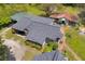 Aerial view of a house with a gray roof and lush landscaping, accompanied by quaint outbuildings at 215 Fair St, Loganville, GA 30052