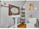 Charming bathroom features a pedestal sink, unique mirror, and toilet at 215 Fair St, Loganville, GA 30052